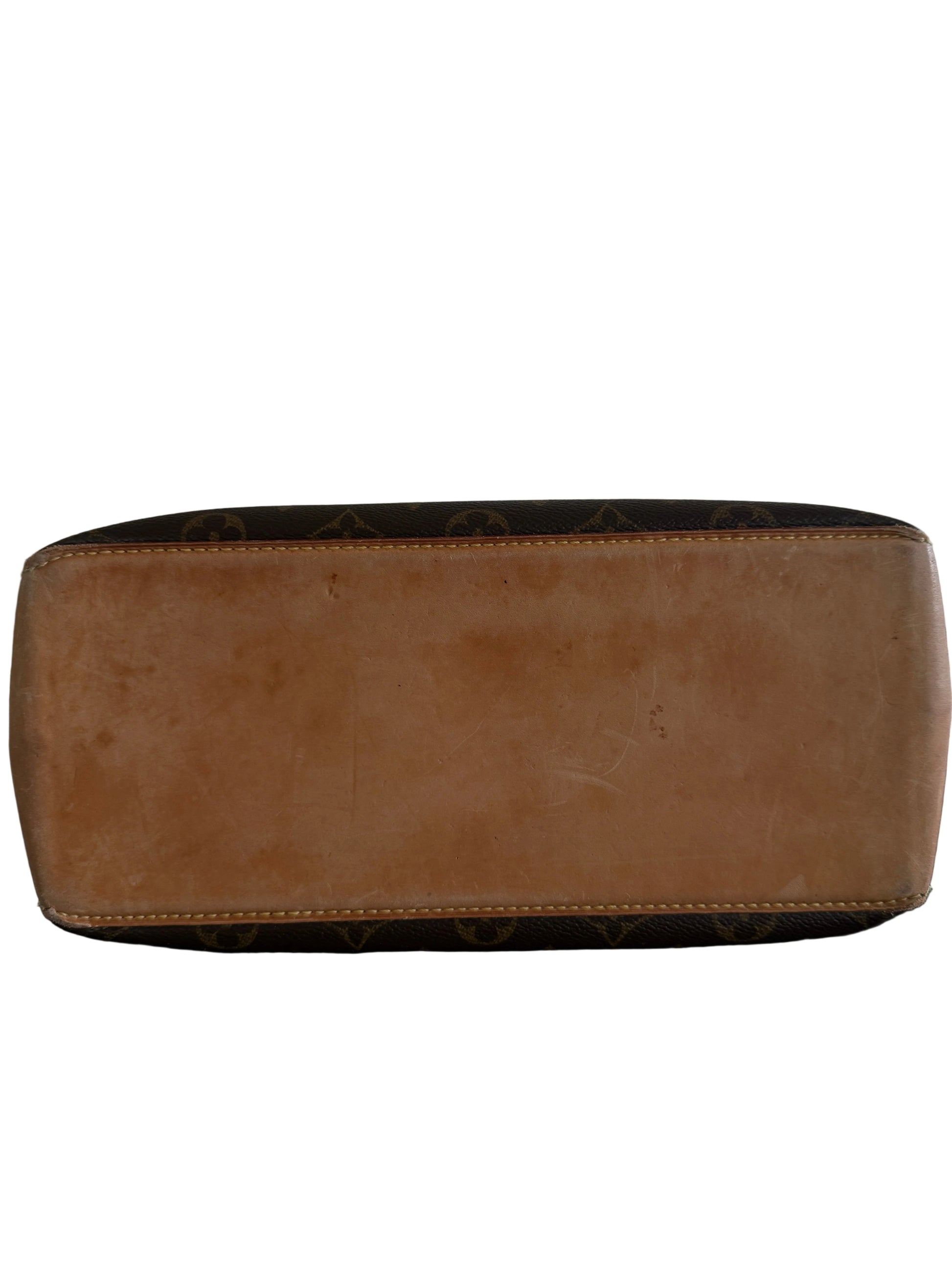 Brown leather handbag with patterned design on a dark surface