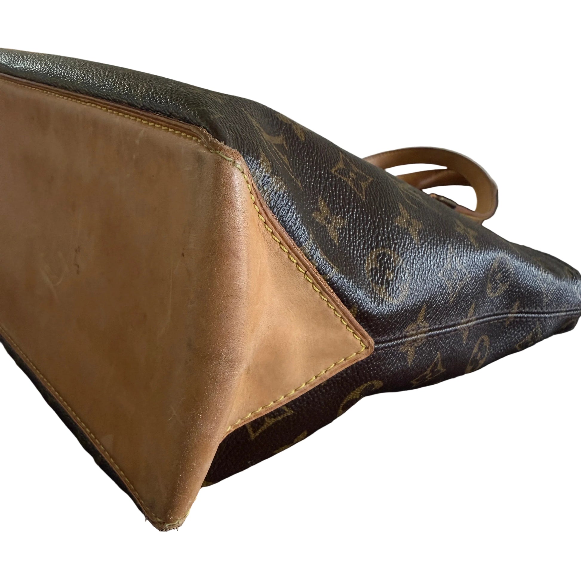 Brown leather handbag with visible brand logo against a dark background