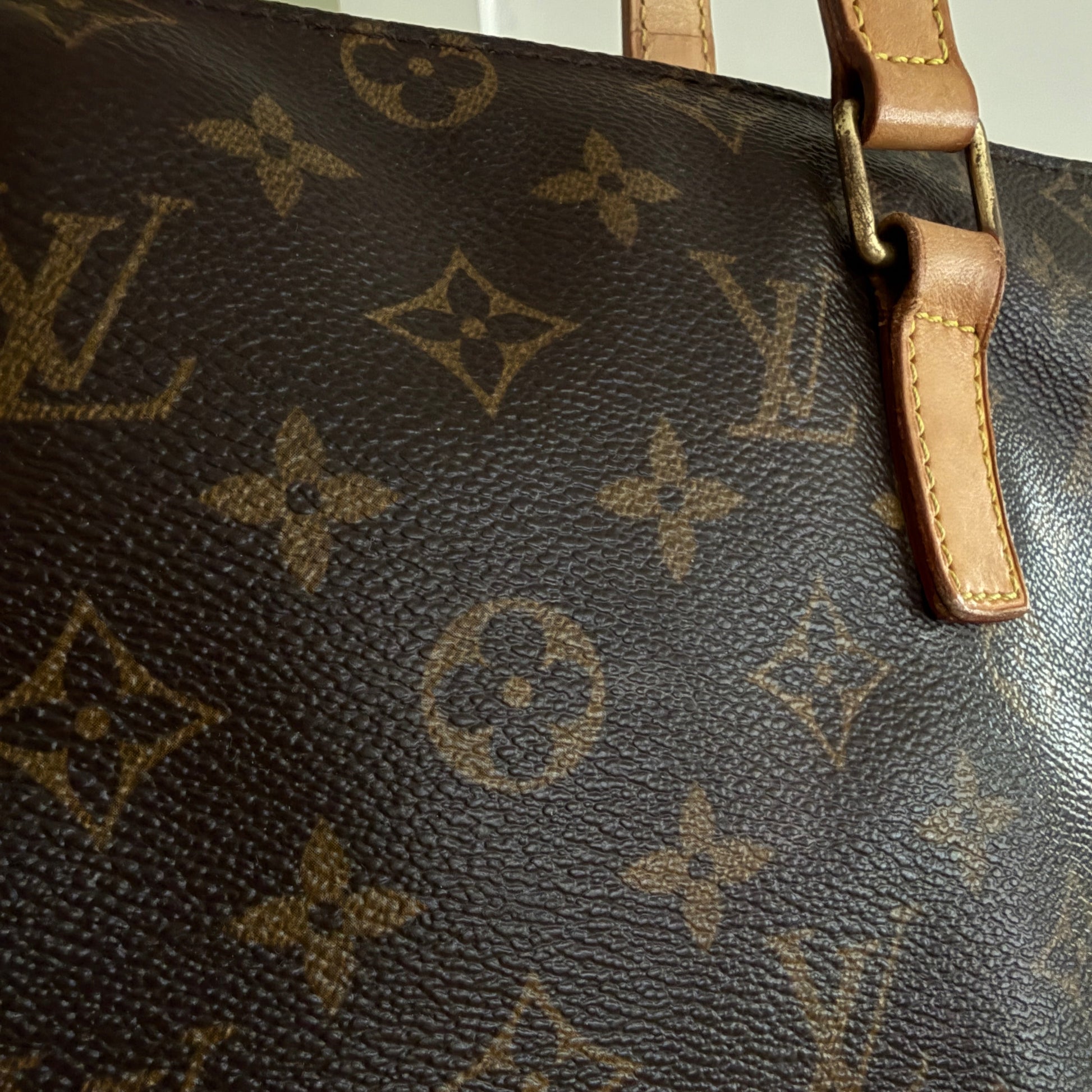 Close-up of a Louis Vuitton monogram handbag with visible logo.